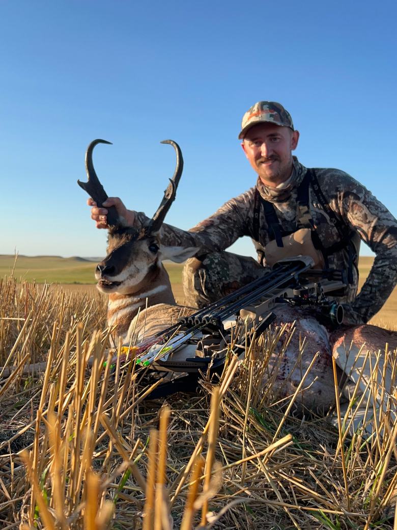 Hunter holding a pronghorn antelope buck by the horns