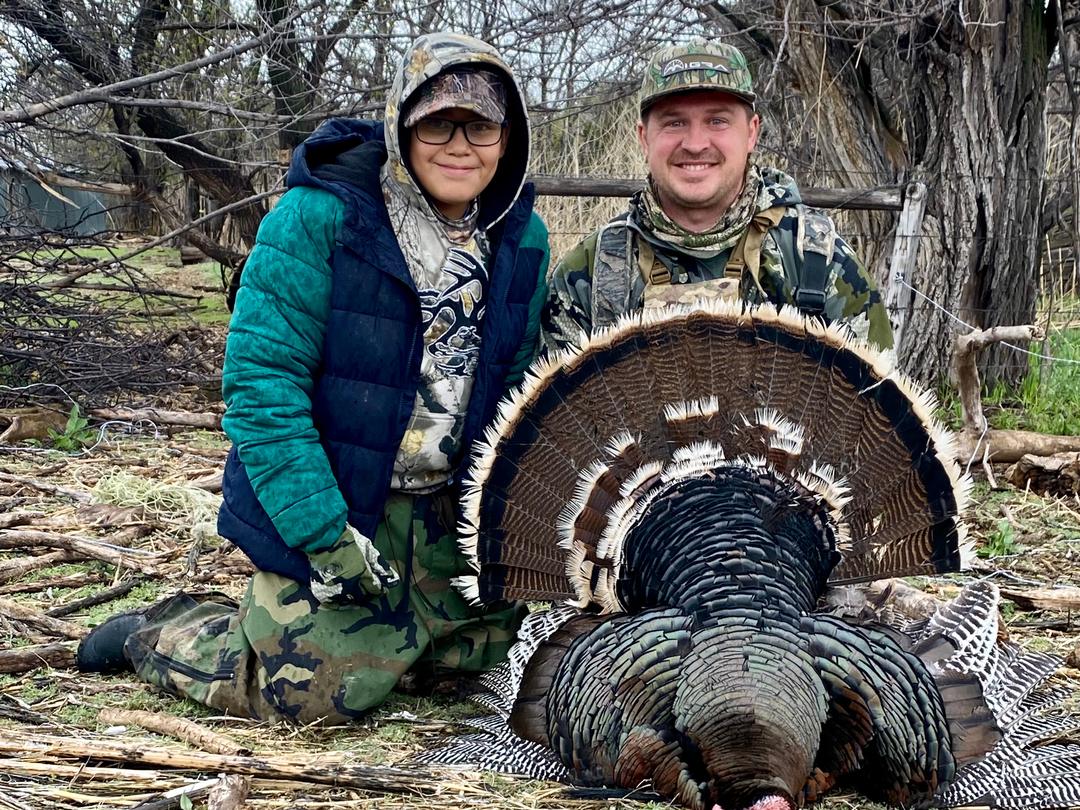 Hunters with a pair of Merriam's turkeys taken on a private ranch