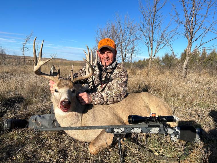 Bowhunter with a mule deer buck taken during the archery season