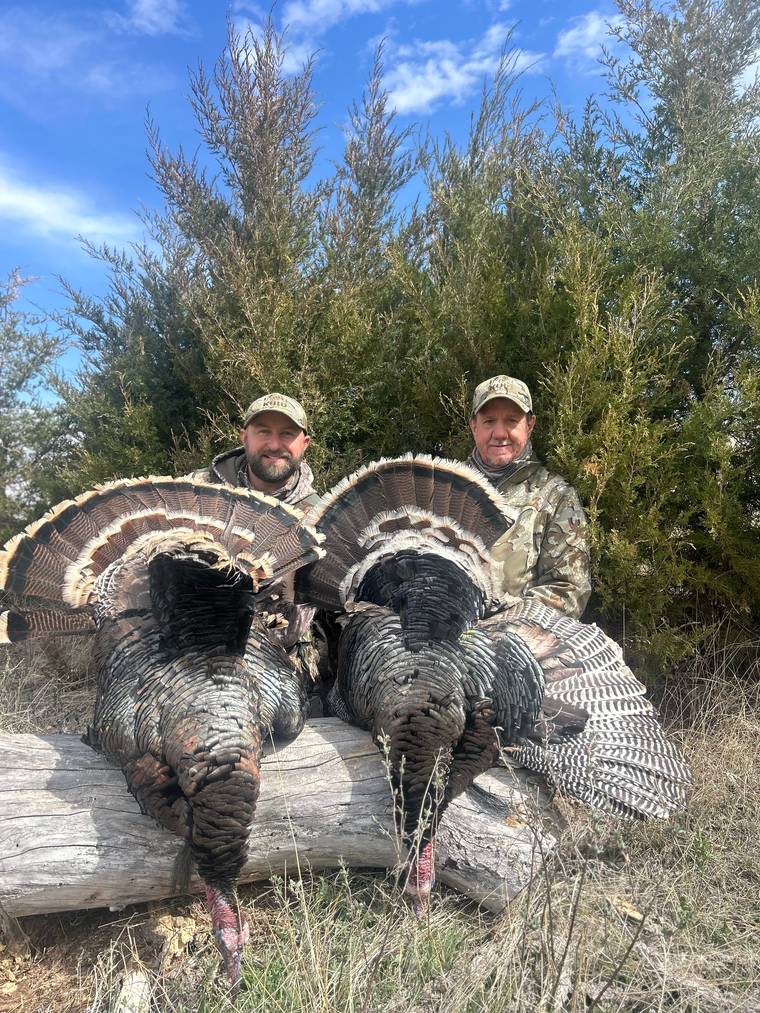 Hunter holding a Merriam's gobbler in a South Dakota pine draw